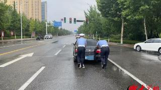 大雨“惹祸”导致车辆熄火 交警瞬变“推车汉”消除隐患