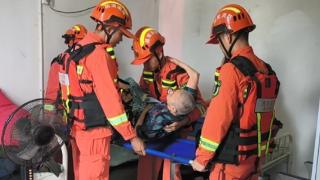 浏阳市消防员强降雨致部分地区积水严重消防员合力将老人抬上楼