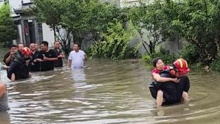 暴雨致岛城多人被困 消防员在齐腰深的水中背老人脱险