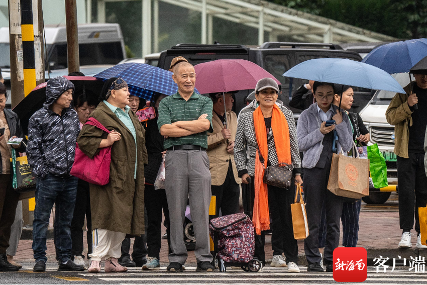 组图 | 冷空气叠加阴雨天 海口市民出行时“加码”装备