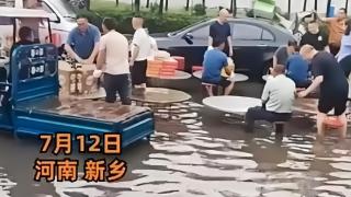 河南暴雨 宾客坐积水中吃席