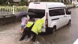 暴雨致车抛锚 交警涉水推车